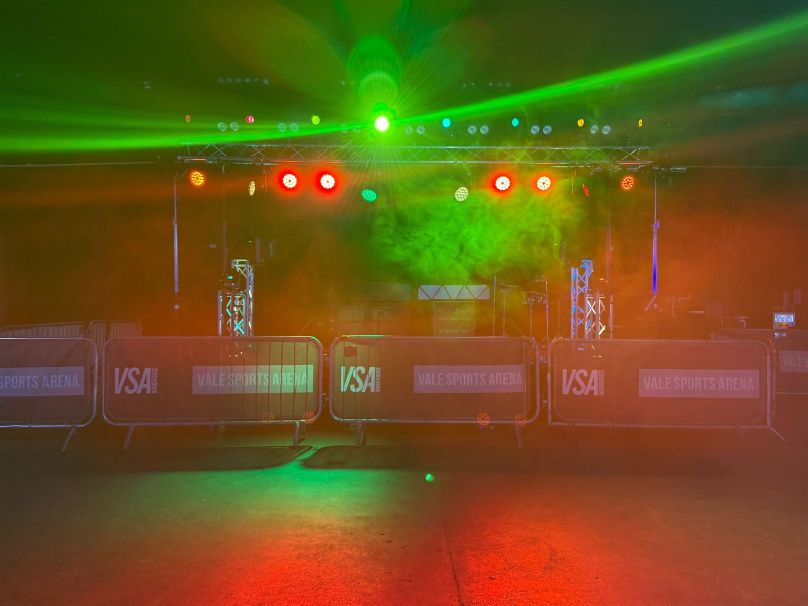 Green laser beams and haze over the arena floor at Vale Sports Arena
